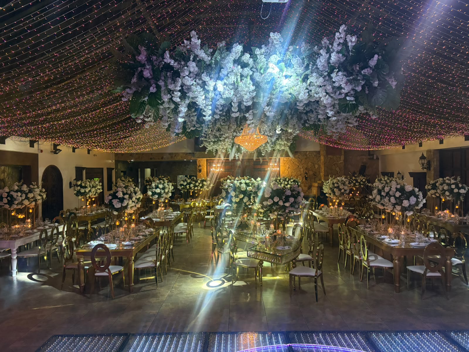 Salón decorado con instalación floral colgante e iluminación cálida